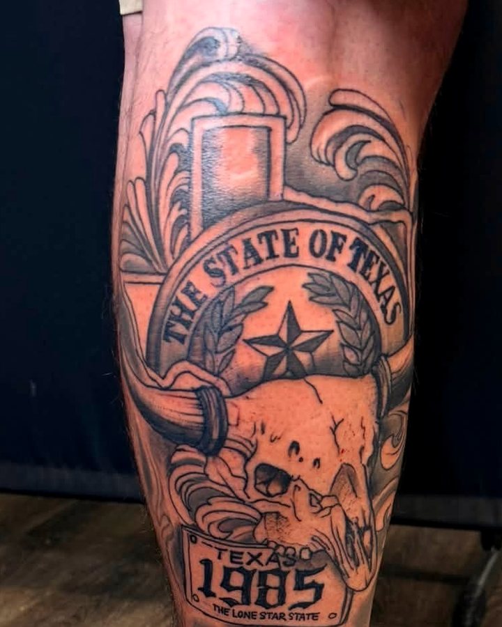 Ornamental black-and-grey calf piece — a State of Texas banner over a longhorn skull and a 1985 plate.