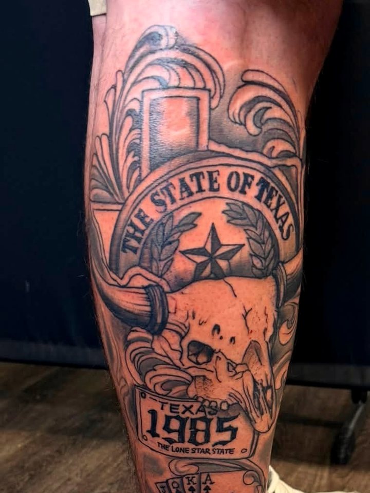 Ornamental black-and-grey calf piece — a State of Texas banner over a longhorn skull and a 1985 plate.